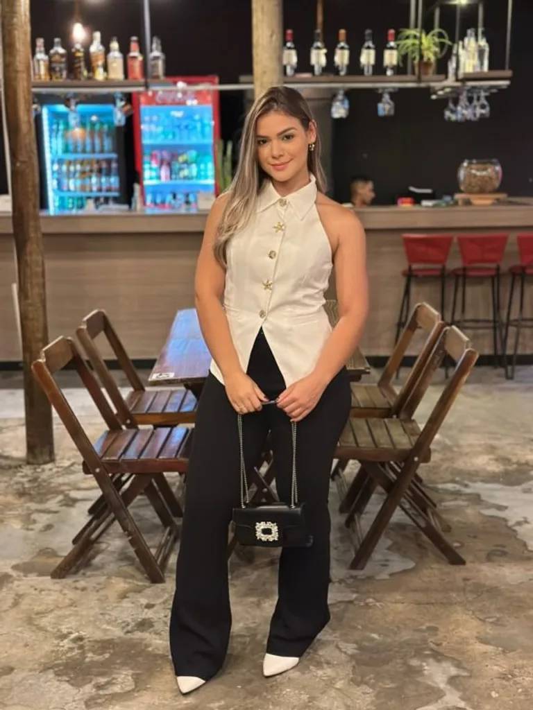 Foto enviada pela cliente, de colete branco e calça preta